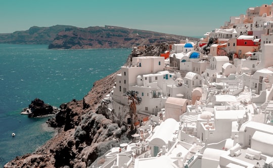 white and brown concrete houses near body of water during daytime in Thíra Greece