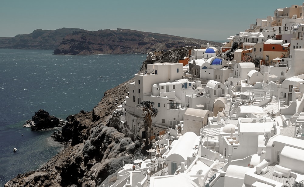 white and brown concrete houses near body of water during daytime