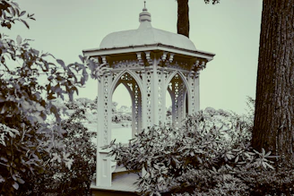 An elegant gazebo canopy with flowing white outdoor curtains gently swaying in the breeze.