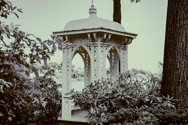An elegant gazebo canopy with flowing white outdoor curtains gently swaying in the breeze.