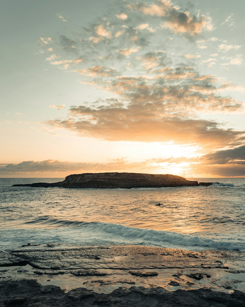 brown rock formation on sea during sunset