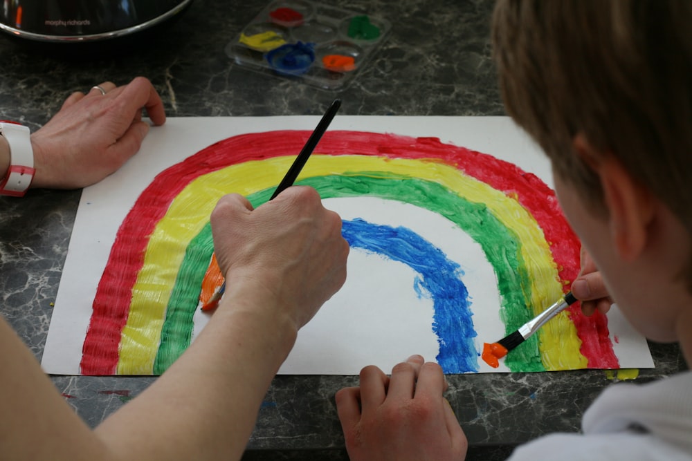 person painting a multi color paint