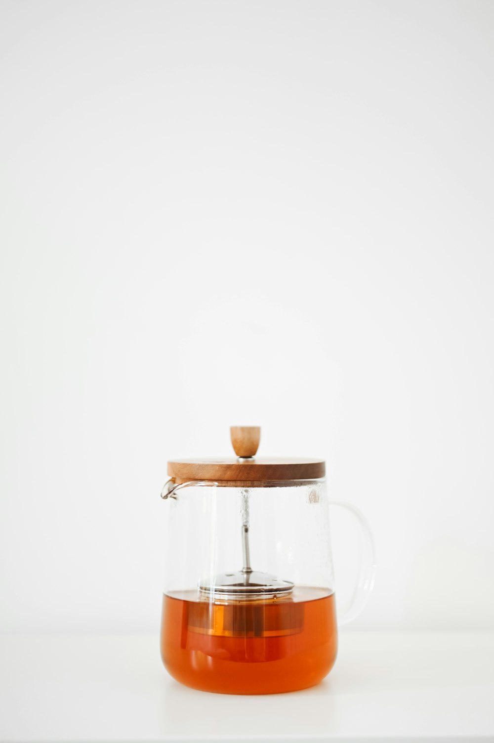 clear glass pitcher with brown liquid