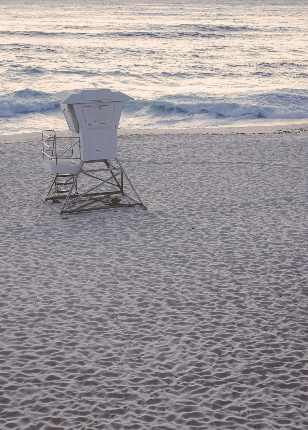 white and gray lifeguard chair on beach shore during daytime