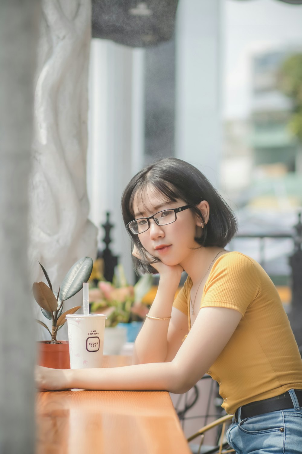 woman in yellow shirt wearing black framed eyeglasses