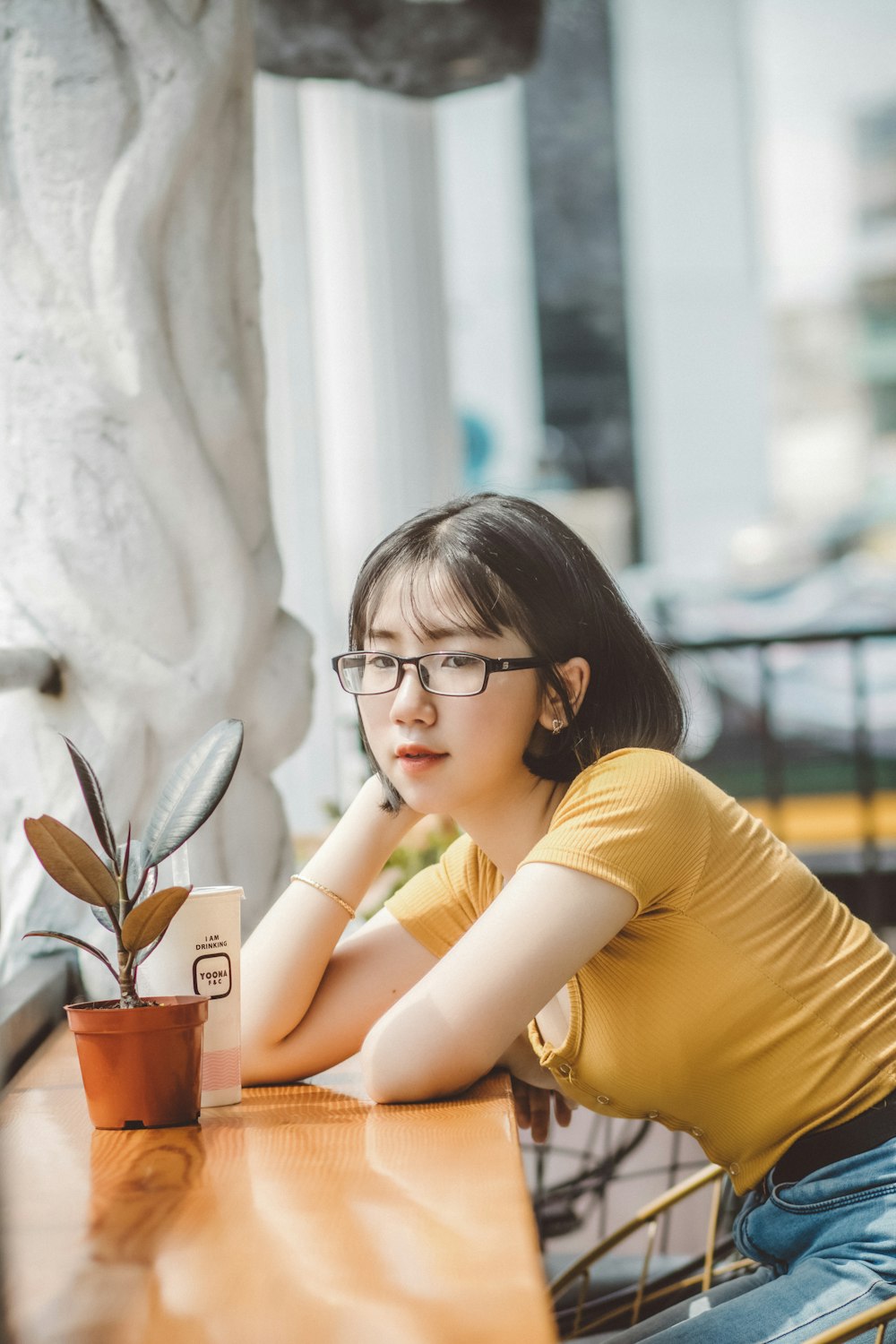 woman in yellow shirt wearing black framed eyeglasses