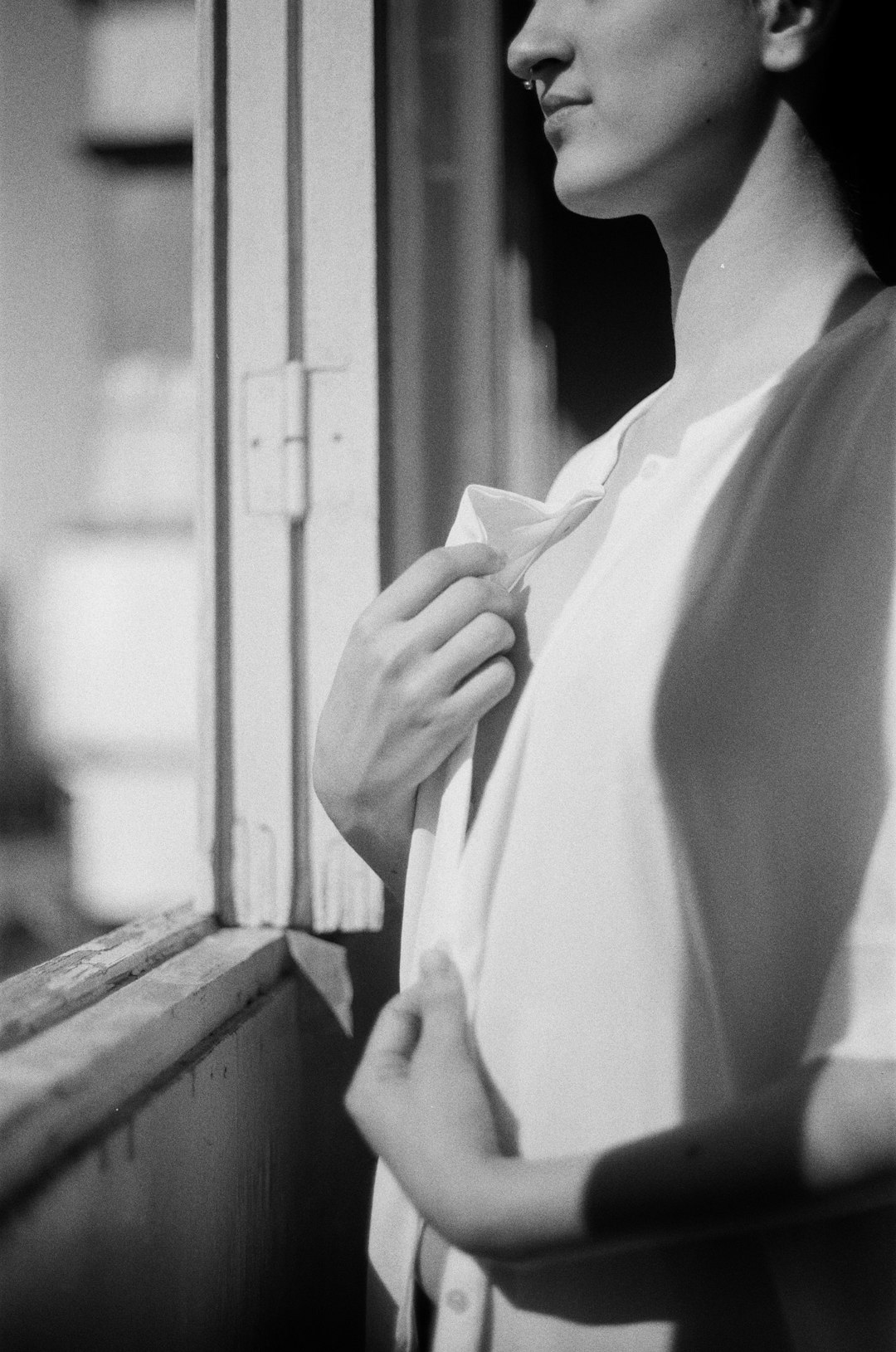 man in white dress shirt standing near window