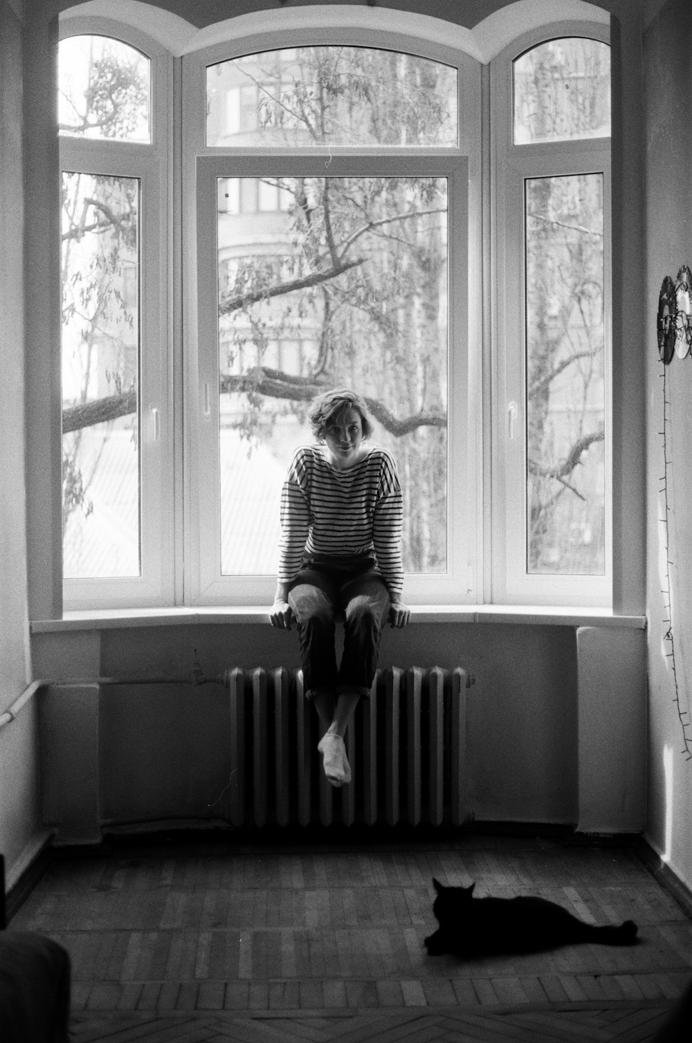 woman in striped dress sitting on window