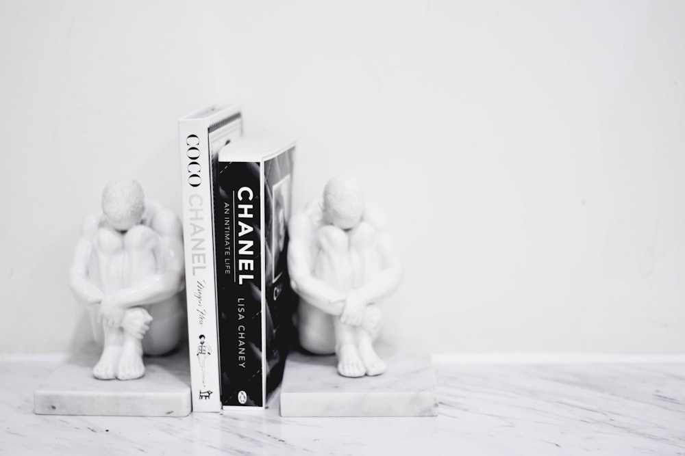 grayscale photo of man and woman ceramic figurine