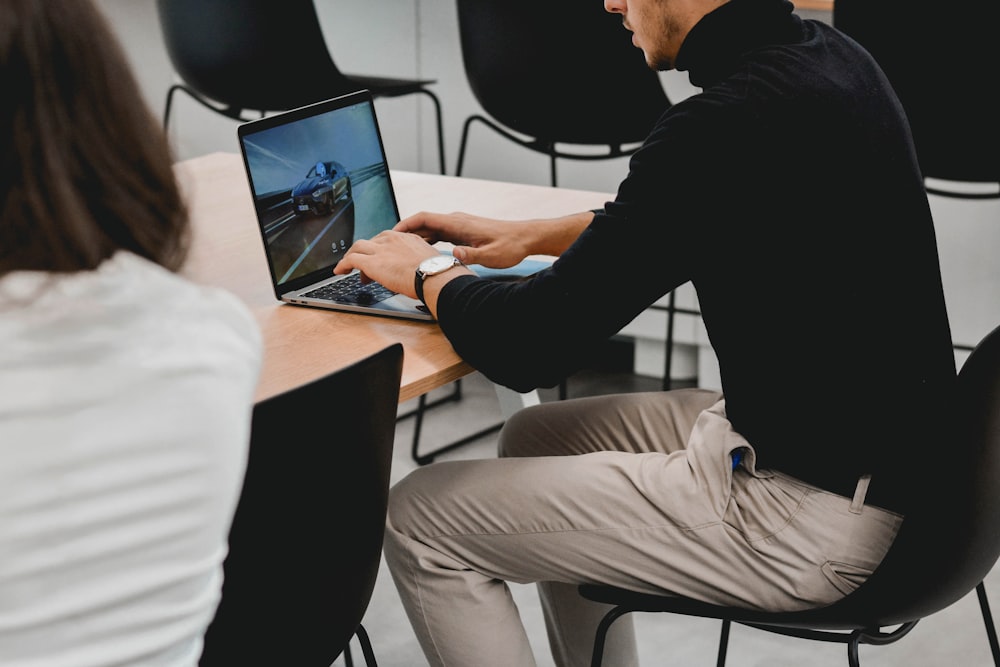 man in black long sleeve shirt using macbook pro