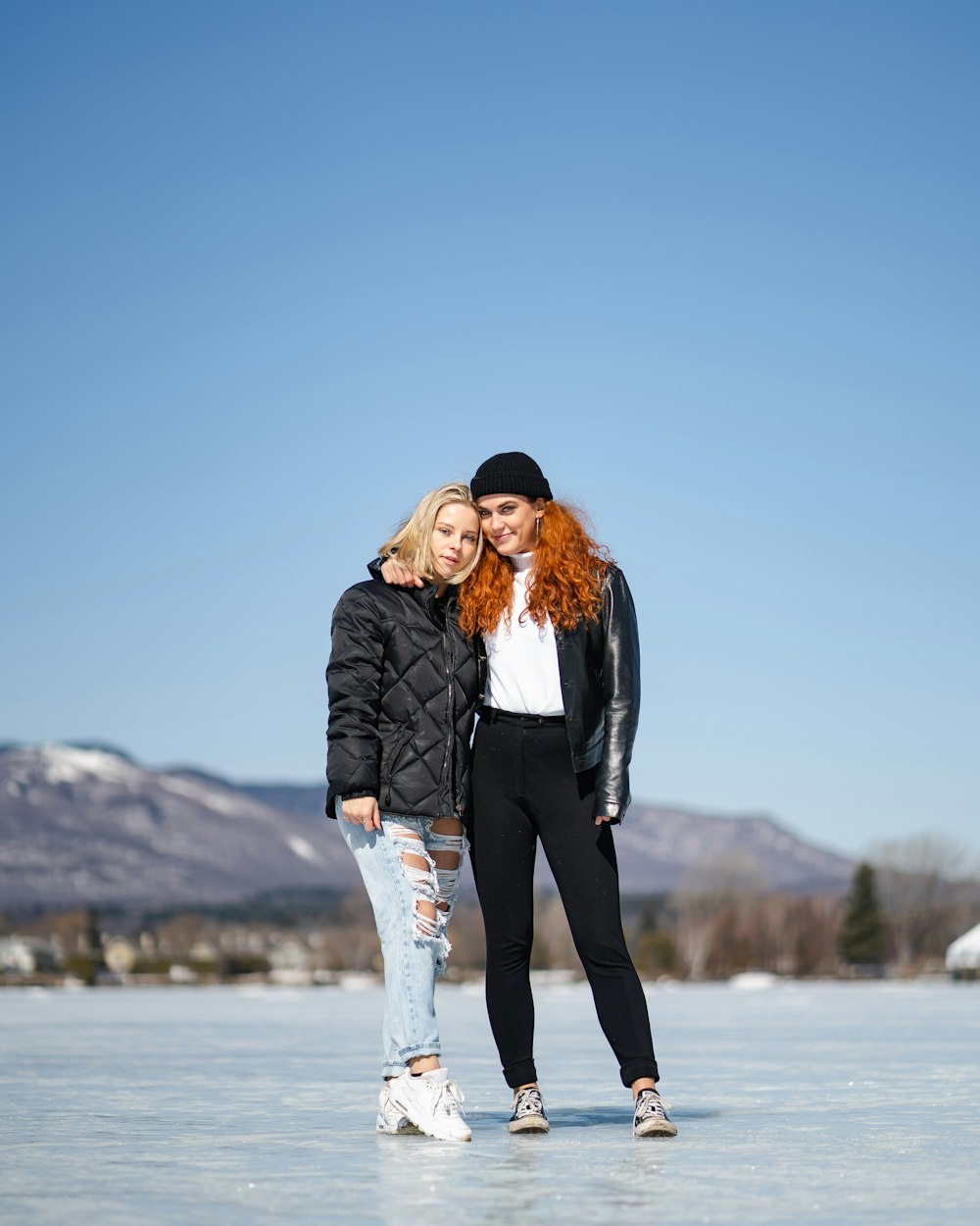 man in black jacket hugging woman in white jacket