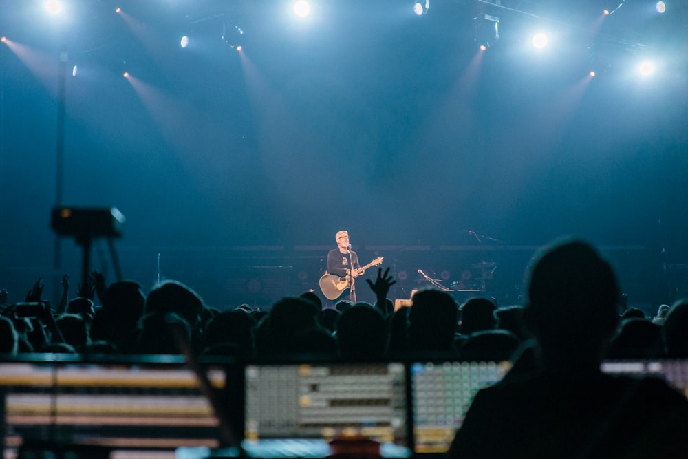 man in black shirt singing on stage