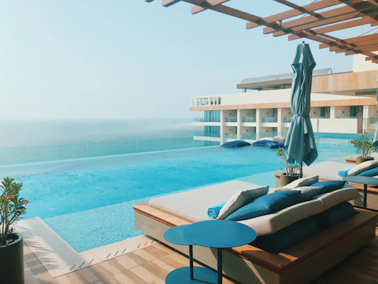brown wooden lounge chairs near body of water during daytime