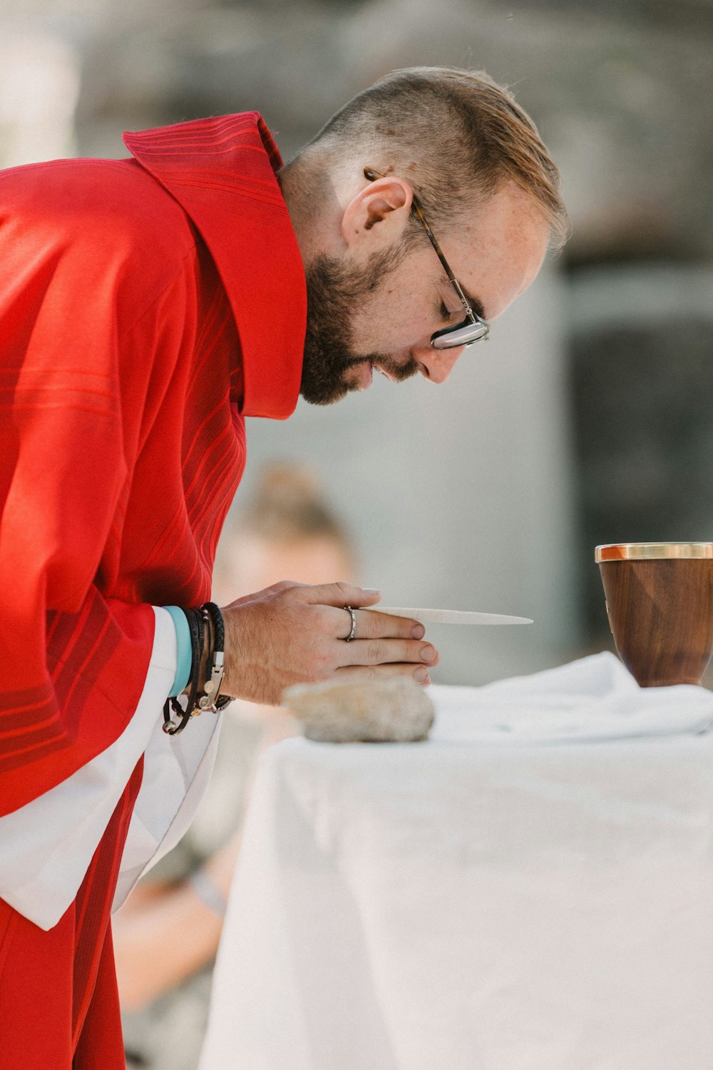 man in red long sleeve shirt holding brown ceramic mug