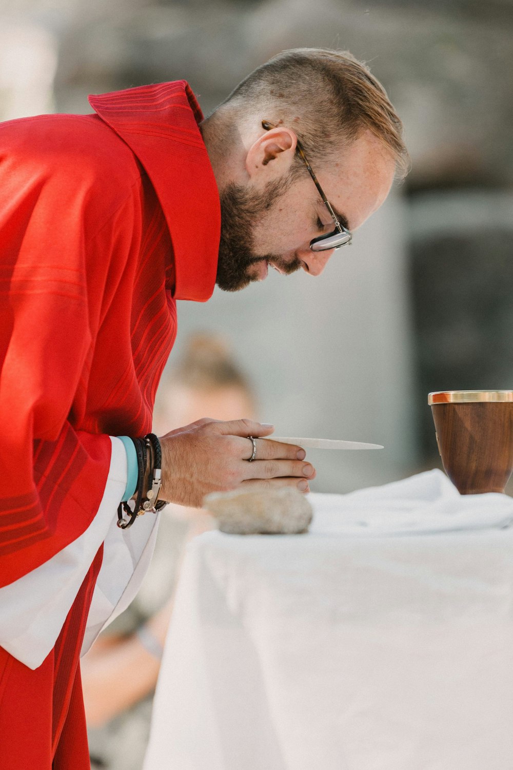 Homme en chemise à manches longues rouge tenant une tasse en céramique marron
