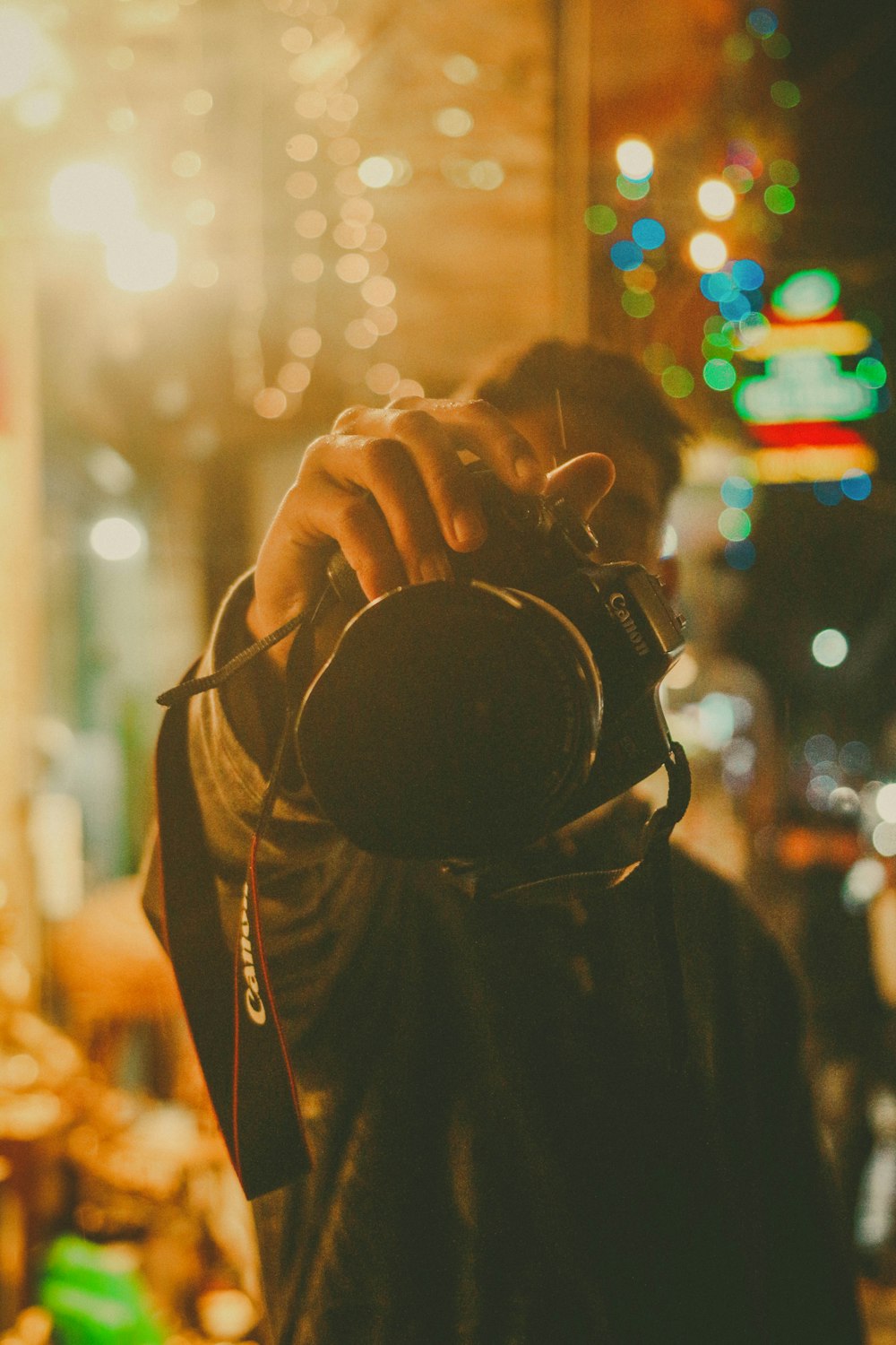 man in black jacket holding black dslr camera