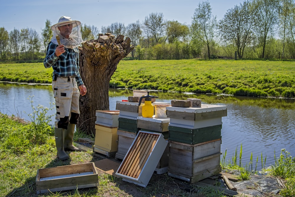 man in white and black plaid shirt standing on brown wooden pallet