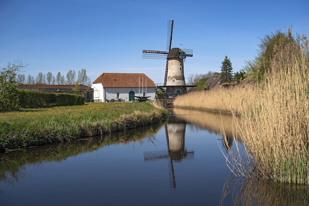 brown and white concrete house beside river under blue sky during daytime