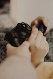 person holding black sony ps 4 controller
