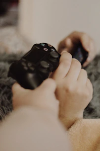 person holding black sony ps 4 controller