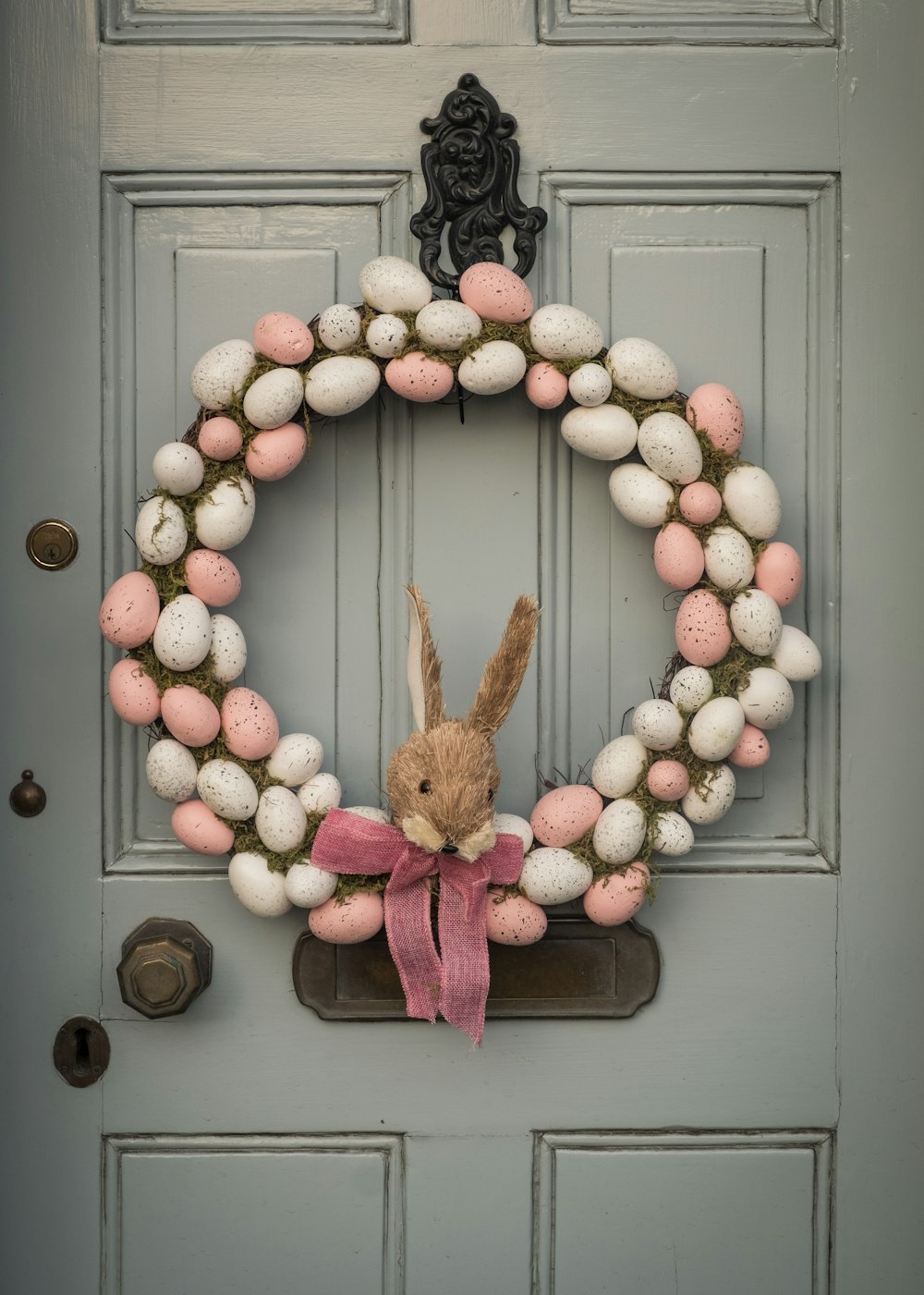 juguete de peluche de conejo marrón en puerta de madera gris