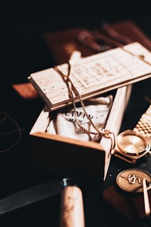 silver round analog watch on brown wooden box