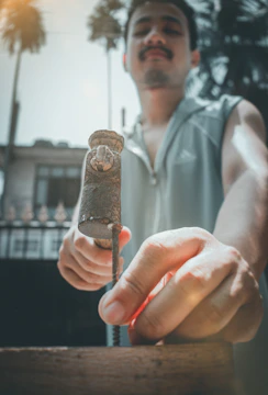 Close-up of hands hammering nails into timber during a build.