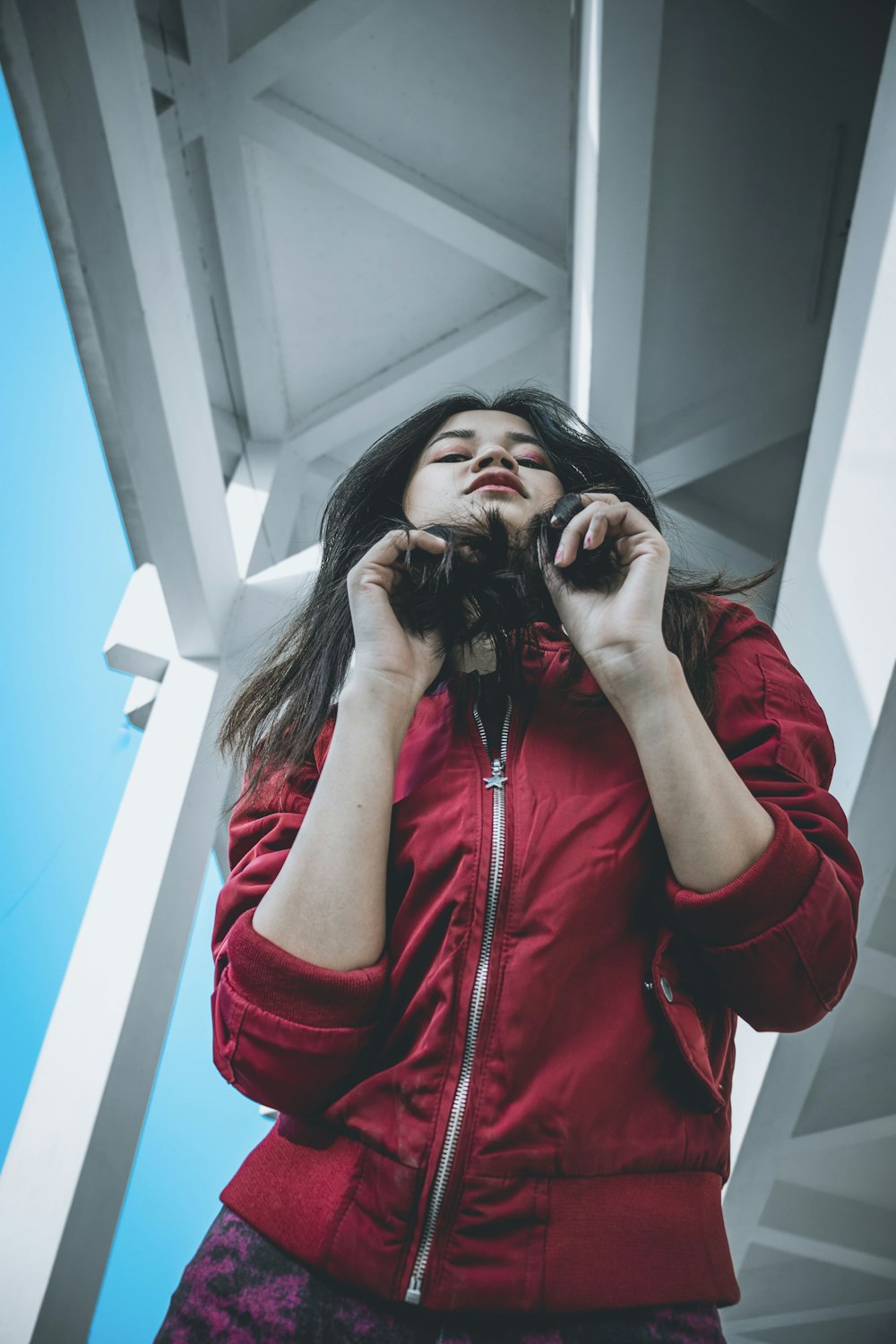 woman in red zip up jacket covering her face