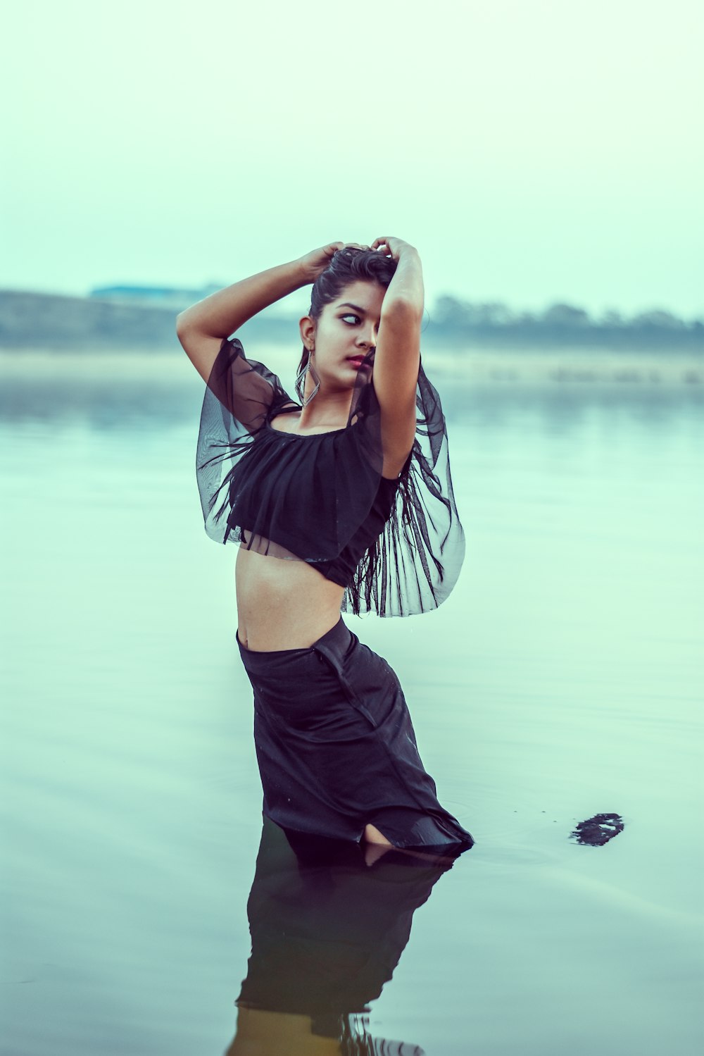 woman in black and white stripe shirt and black skirt standing on water during daytime