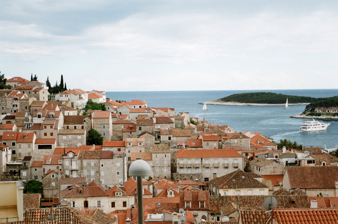 brown and white concrete houses near sea under white clouds during daytime