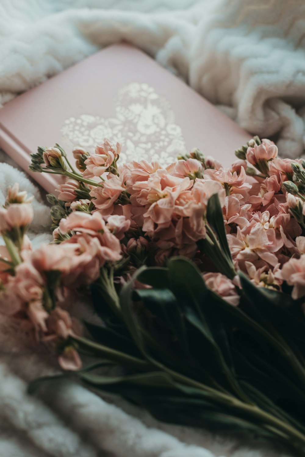 pink and white flowers on white textile