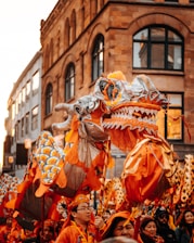 people in orange and white costume walking on street during daytime