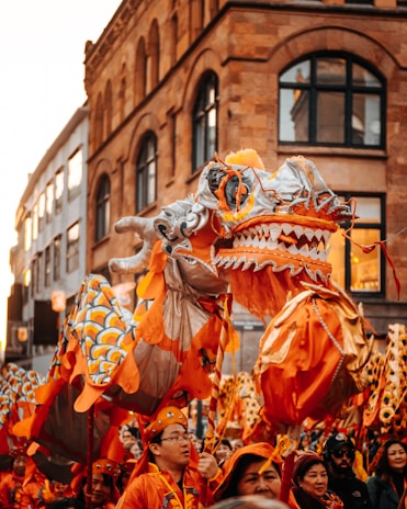 people in orange and white costume walking on street during daytime
