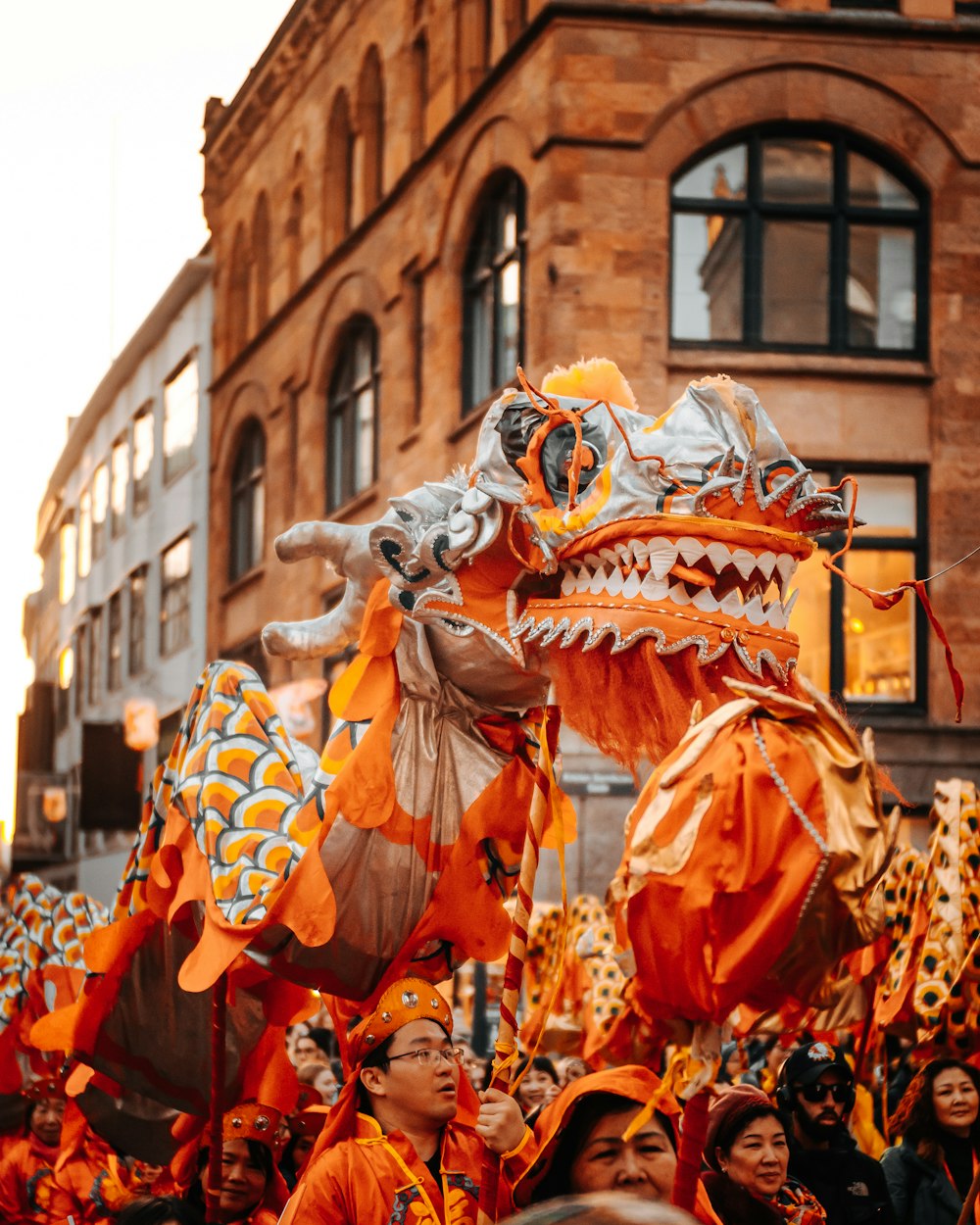 people in orange and white costume walking on street during daytime