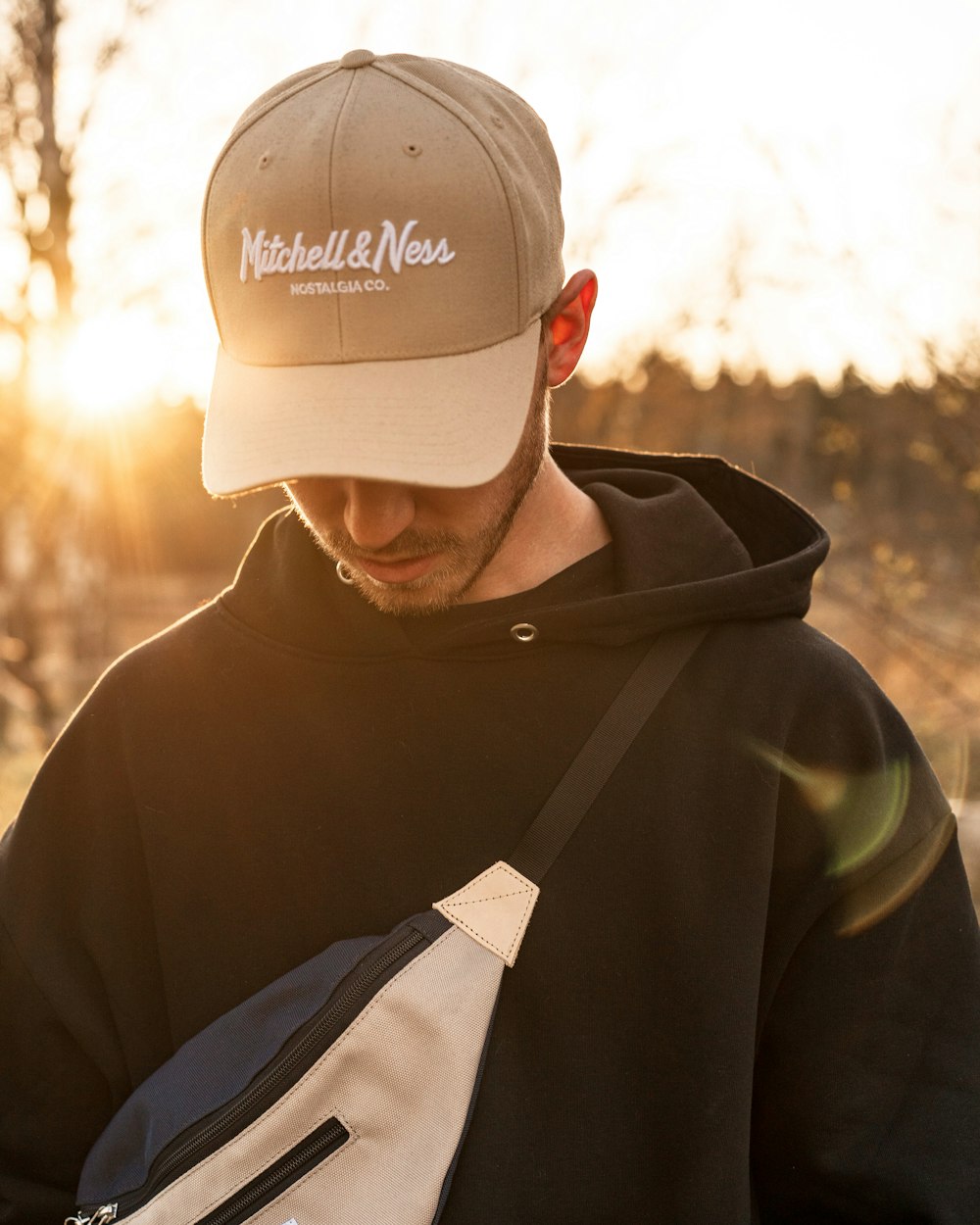 homme en sweat à capuche noir et blanc portant une casquette blanche