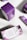 Packages of premium hemp softgels are arranged on a surface. The boxes are predominantly purple with white panels and floral designs. The front of the packaging displays the product name, 'Pure Tranquility', and a brief description of the benefits.