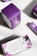 Packages of premium hemp softgels are arranged on a surface. The boxes are predominantly purple with white panels and floral designs. The front of the packaging displays the product name, 'Pure Tranquility', and a brief description of the benefits.