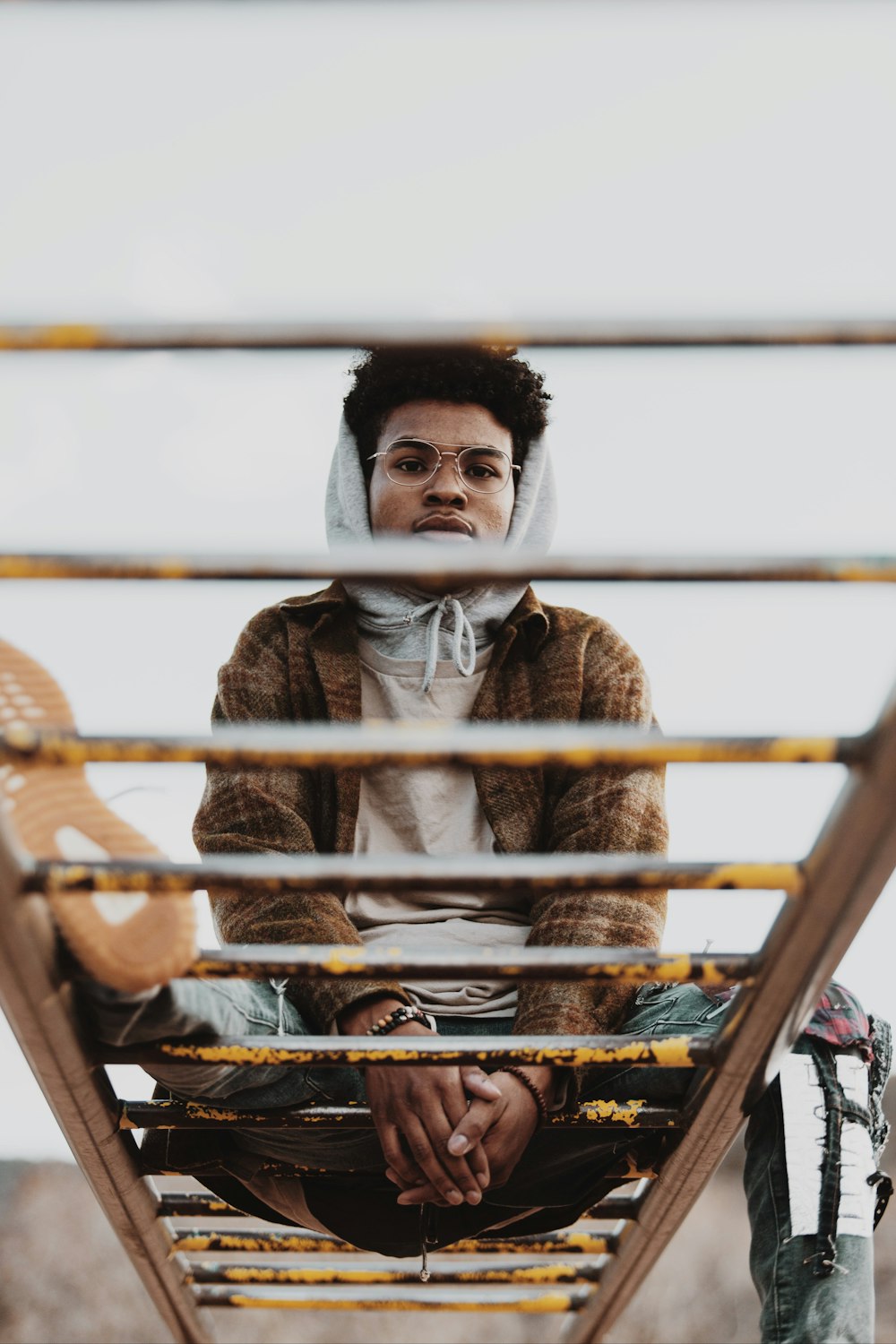 man in brown fur coat sitting on brown wooden chair