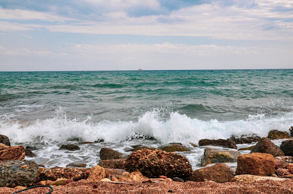 brown rocks near body of water during daytime