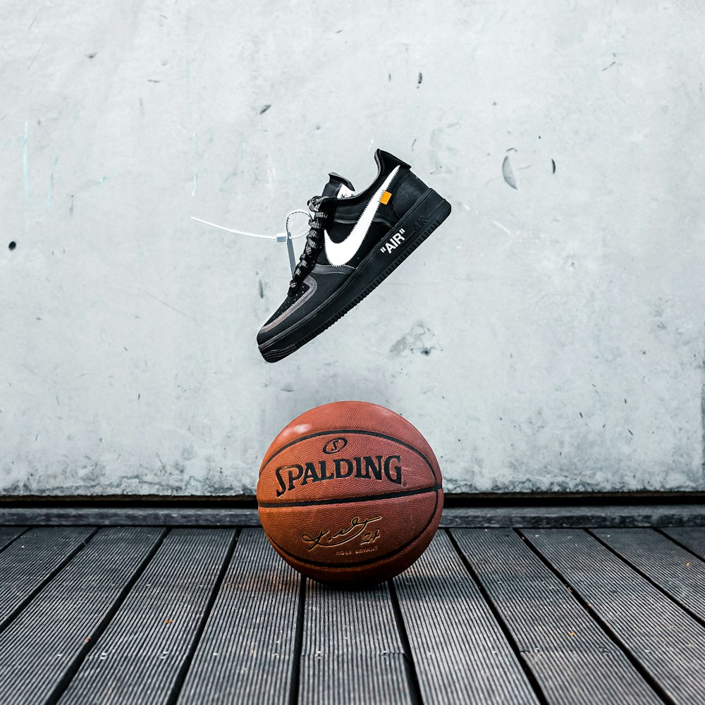 black and white nike basketball shoes on basketball hoop