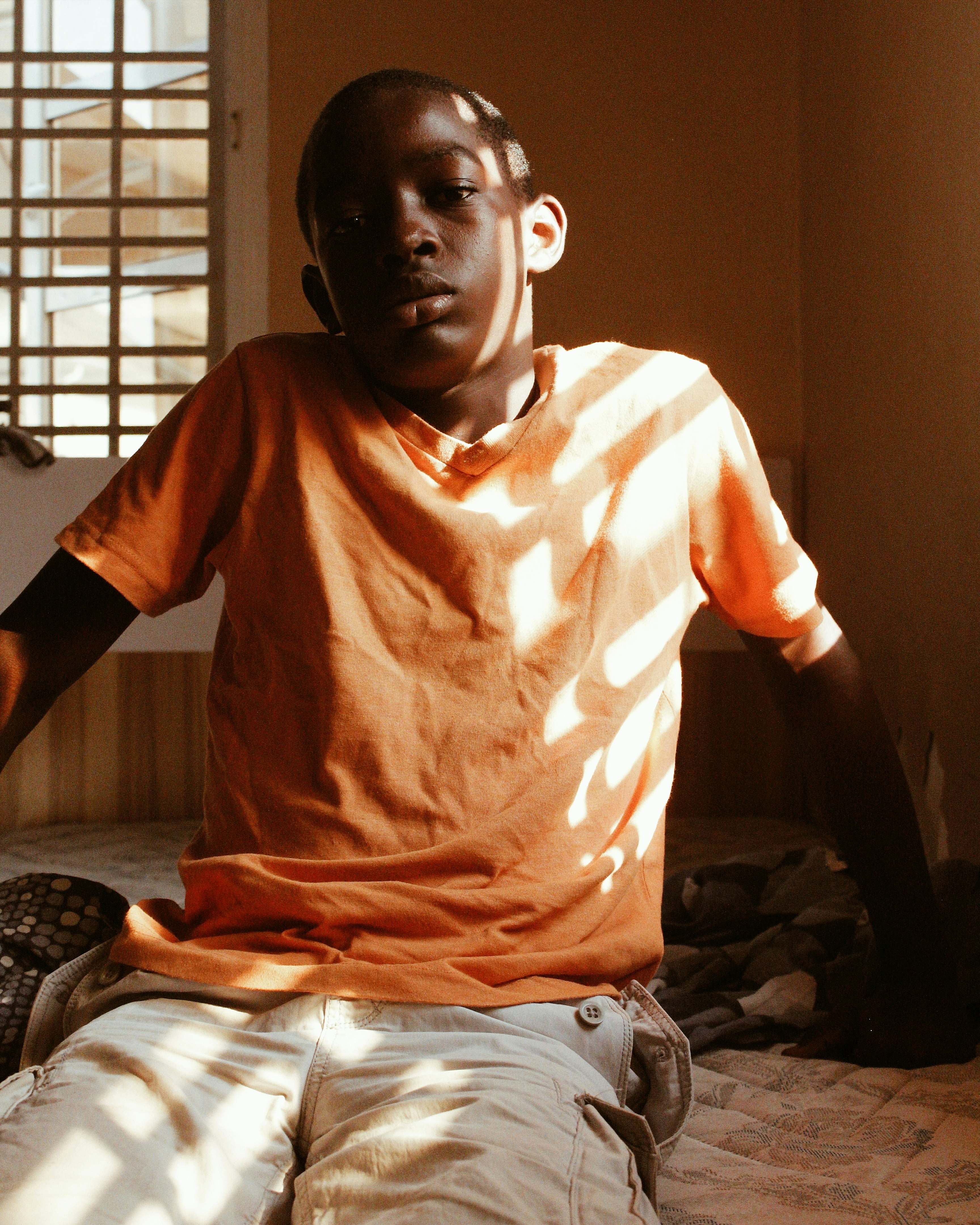 man in orange crew neck t-shirt sitting on black chair