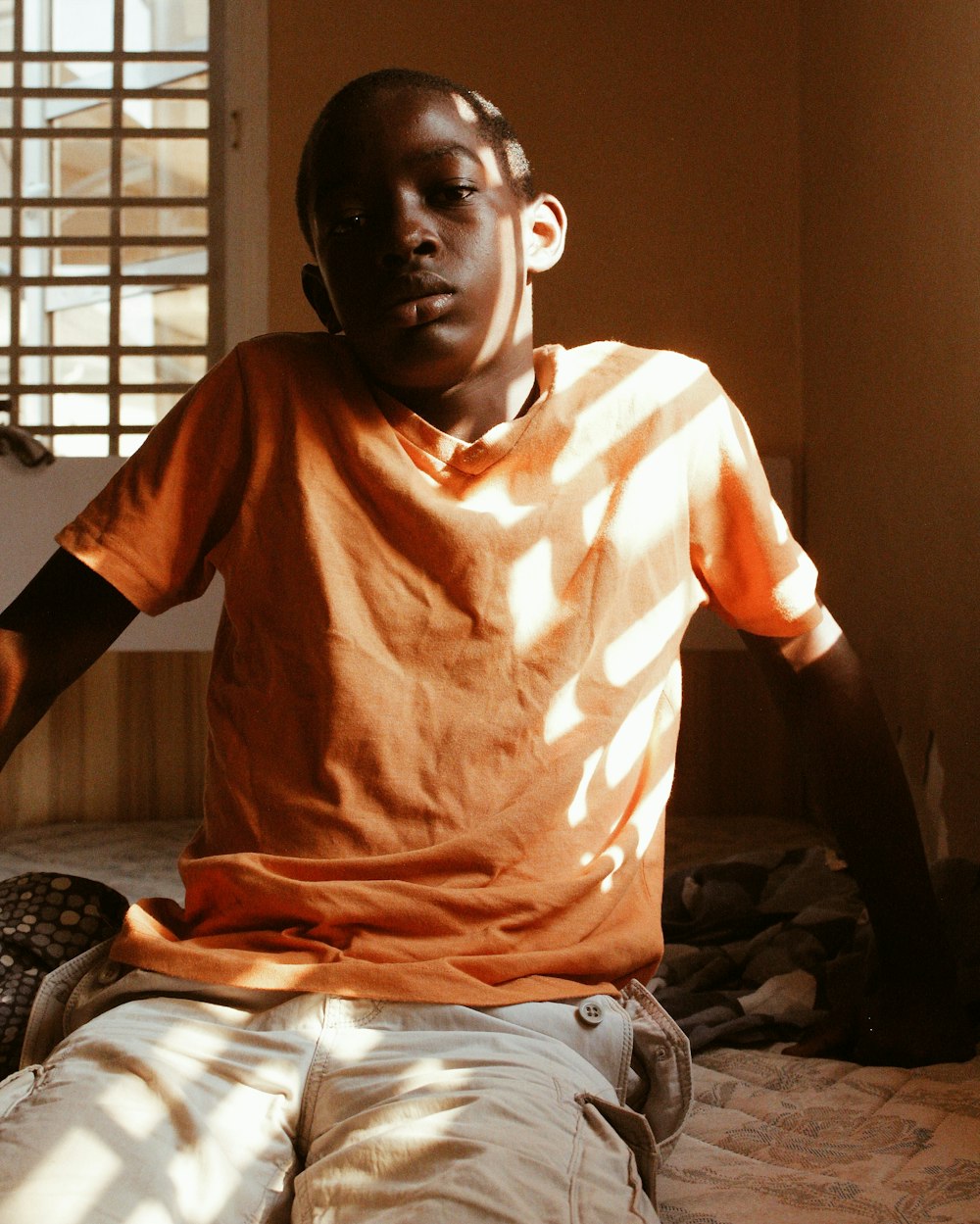 man in orange crew neck t-shirt sitting on black chair