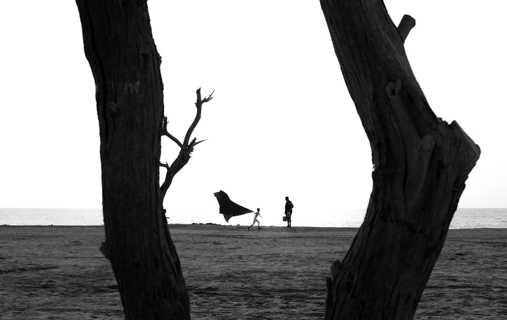 grayscale photo of person walking on beach