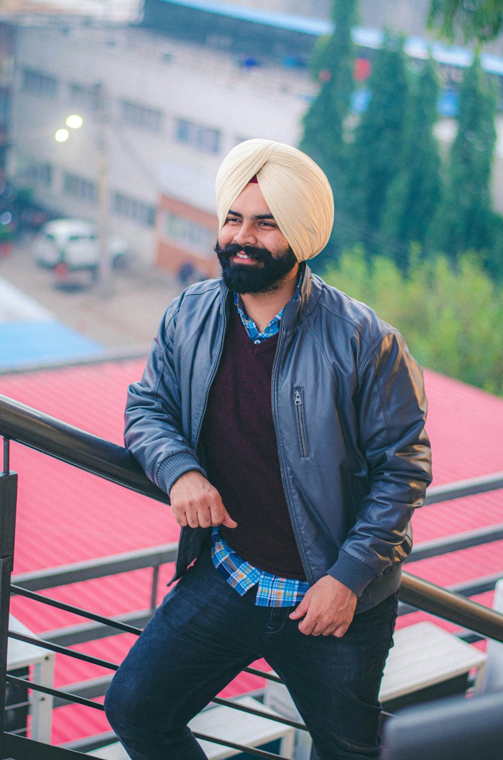 man in black jacket and beige knit cap sitting on brown wooden bench during daytime