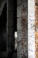 Before and after shot of graffiti removal on a stone facade using laser technology.