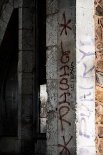 Before and after shot of graffiti removal on a stone facade using laser technology.