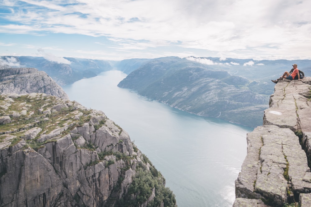 Montagnes vertes à côté du lac sous le ciel bleu pendant la journée