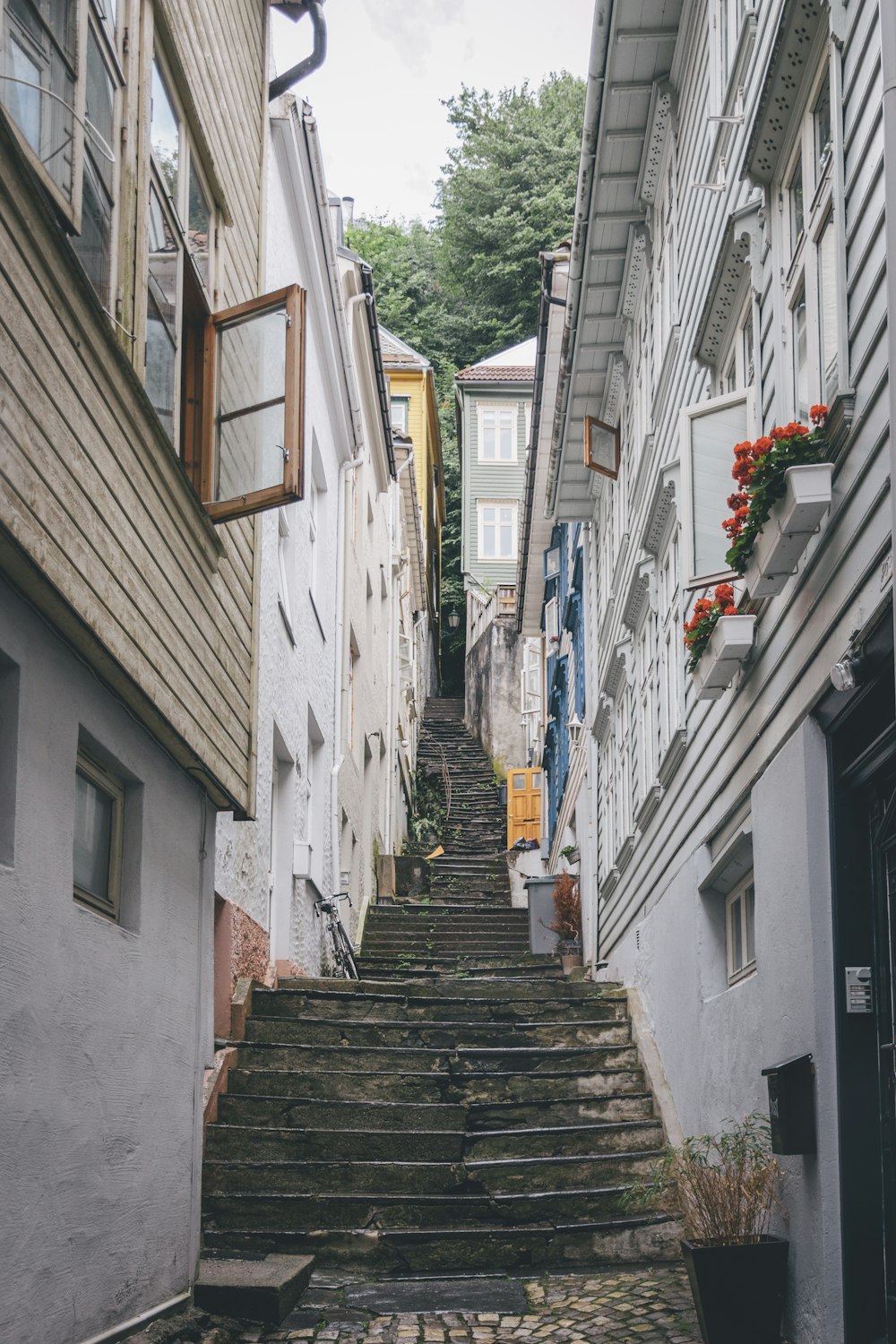 brown wooden staircase between white concrete houses during daytime