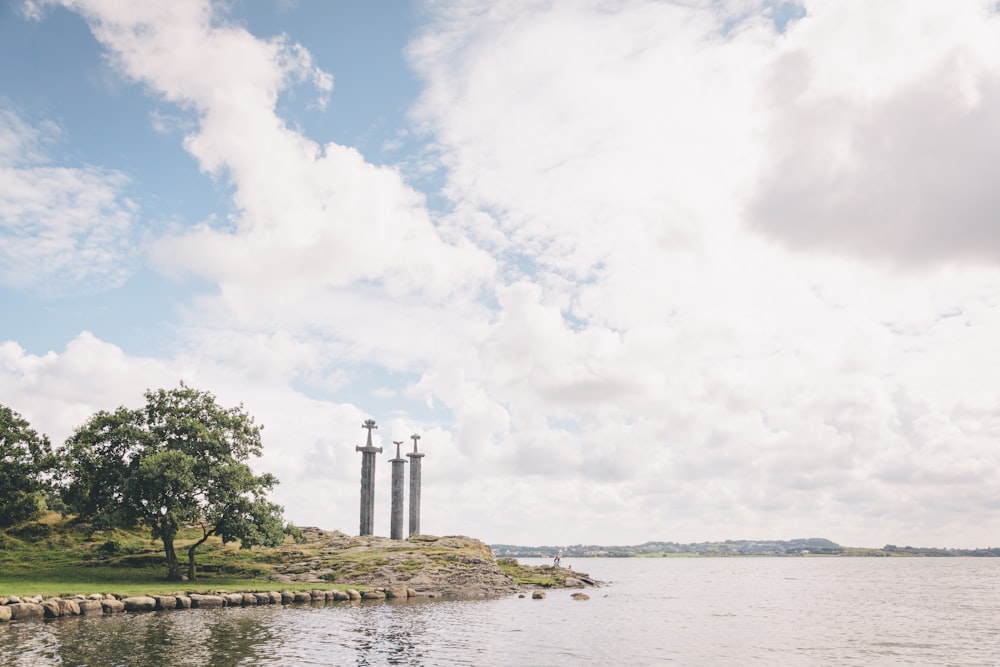 green trees near body of water under white clouds during daytime