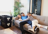 man and woman sitting on beige sofa
